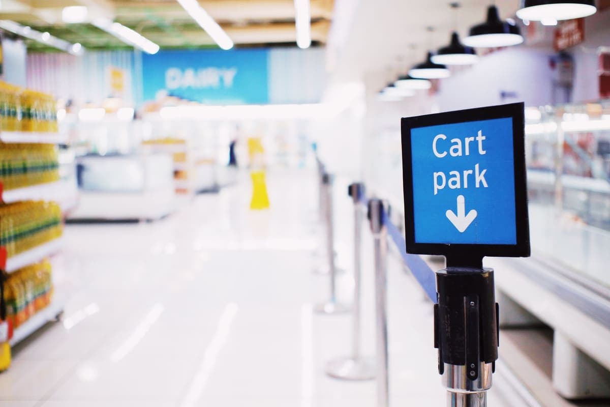 Blue cart park signboard beside a checkout counter in a retail store