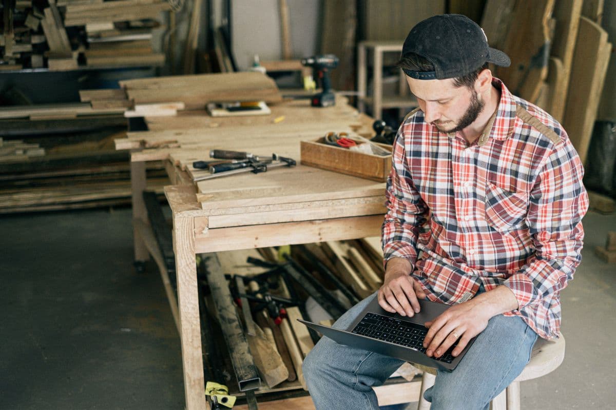Sole trader working on a laptop in a small workshop