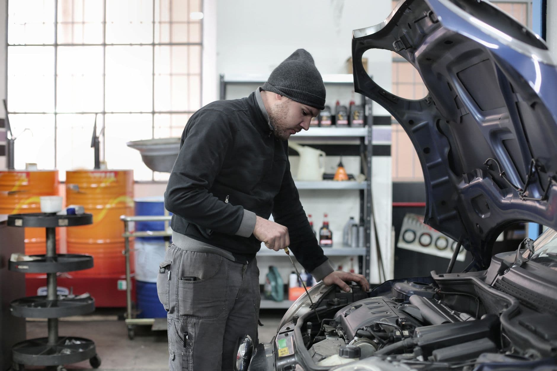 Mechanic checking a car engine in a repair garage