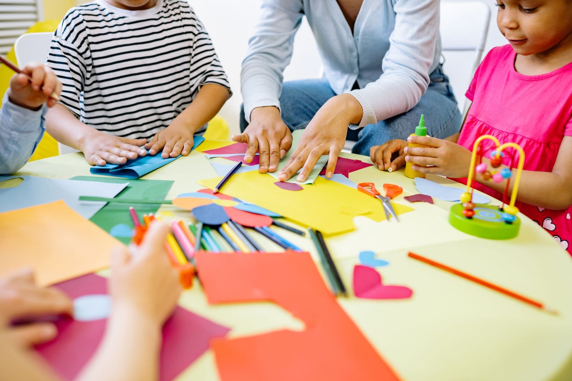 Children working on craft activities together in a bright classroom