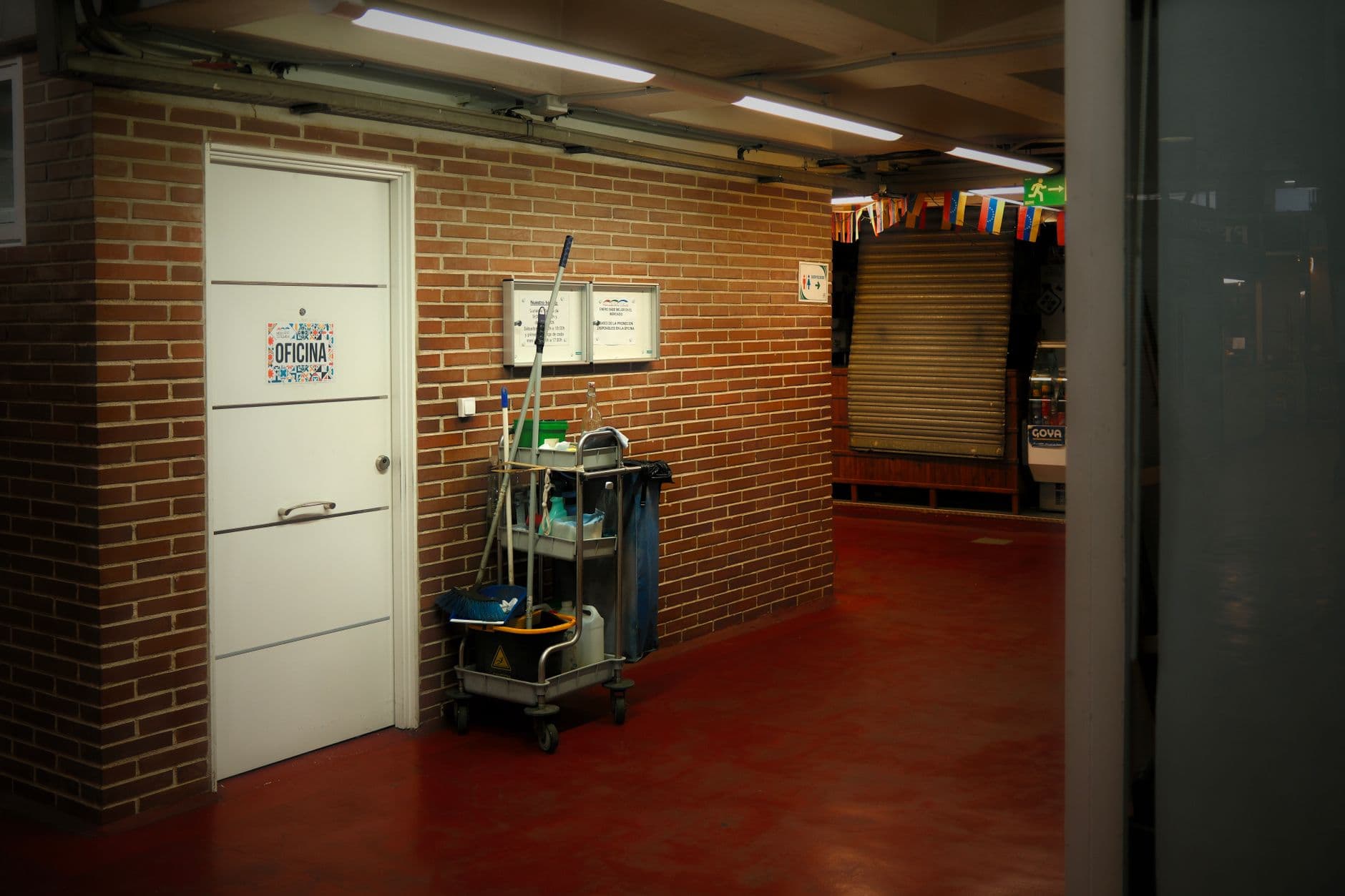 Cleaning cart and supplies in a brightly lit commercial hallway