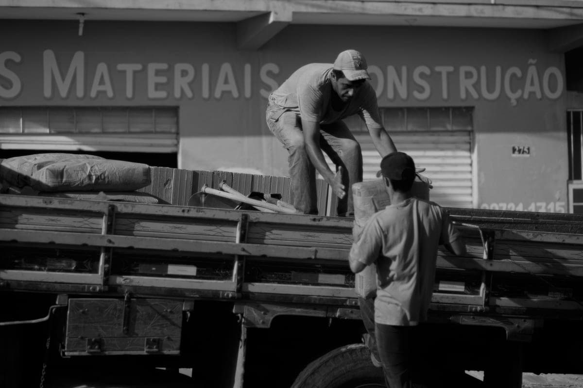 Construction workers unloading materials from a truck at a building site