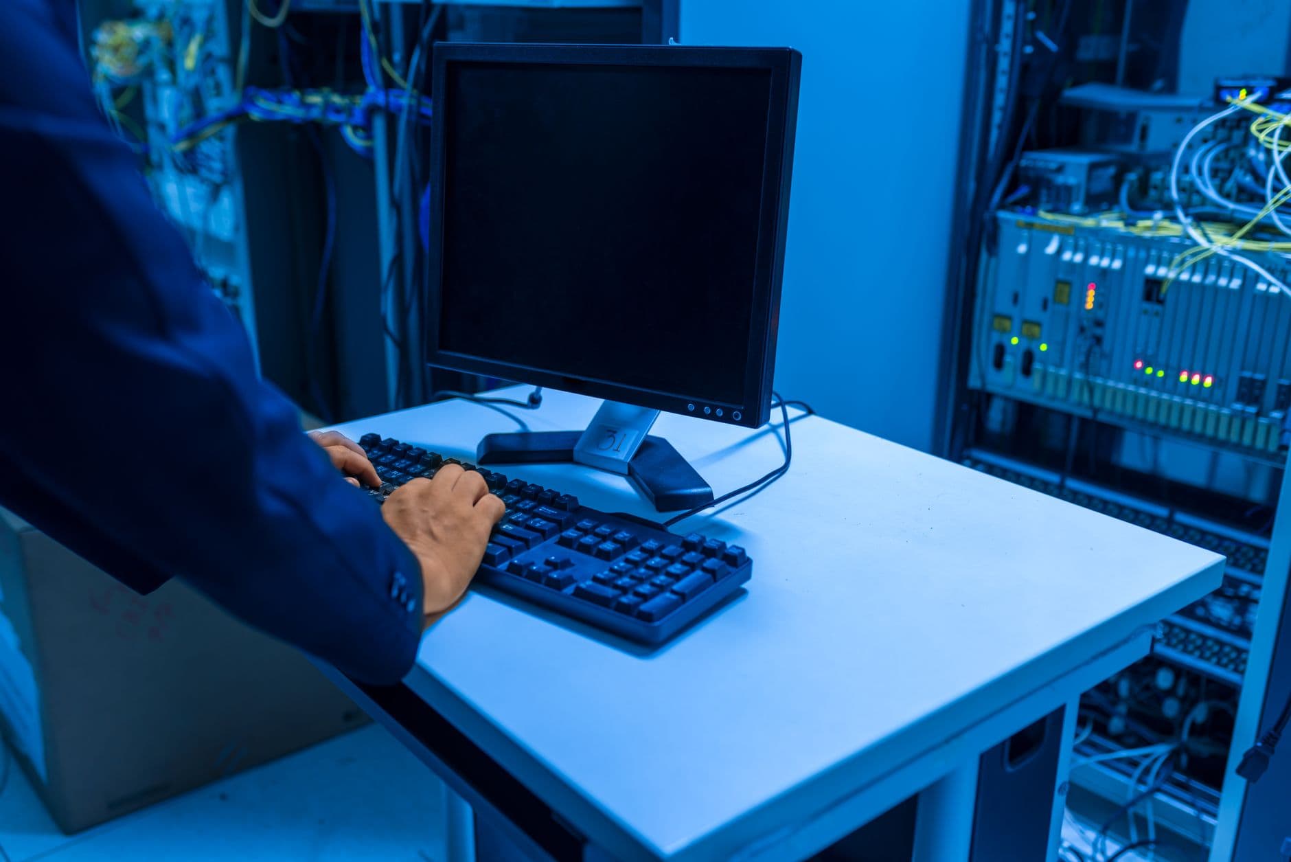 IT technician working on a server rack in a network room