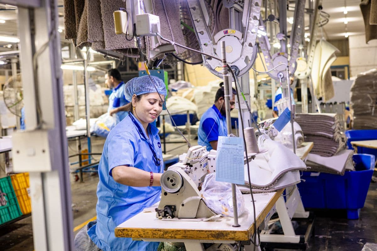 Workers on a factory floor beside industrial machinery