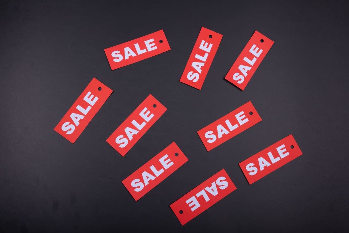 Red retail sale tags arranged on a dark background