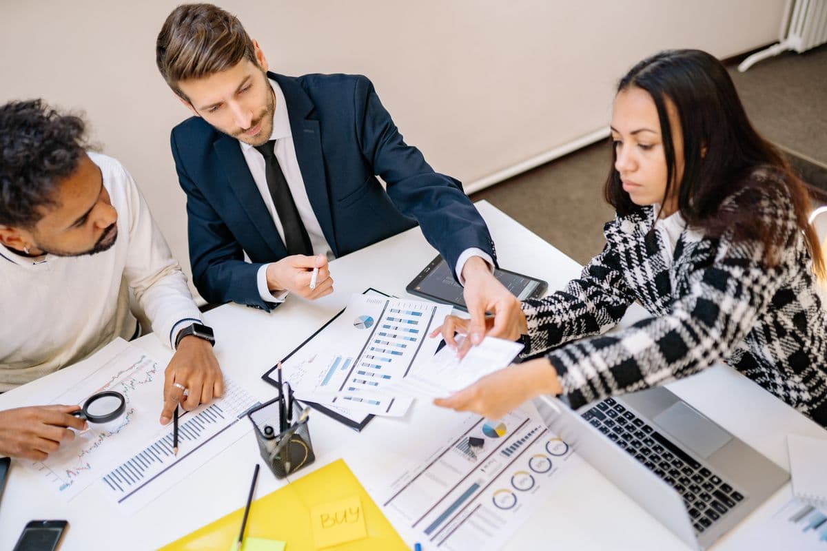 Team reviewing purchasing policy documents in a meeting room