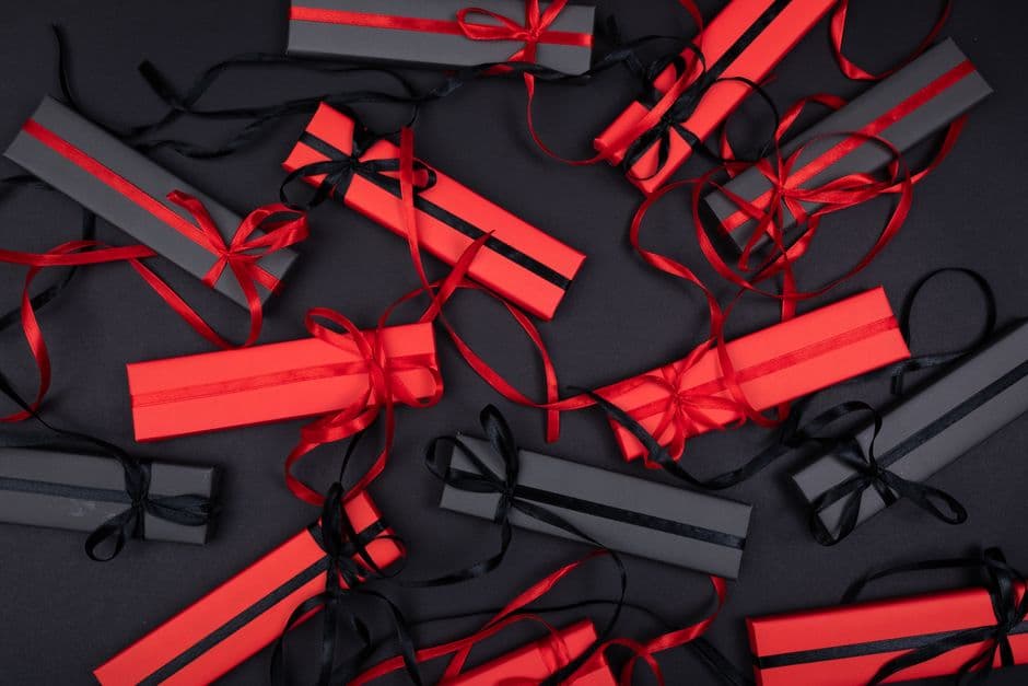Red and black gift boxes tied with ribbon arranged on a table