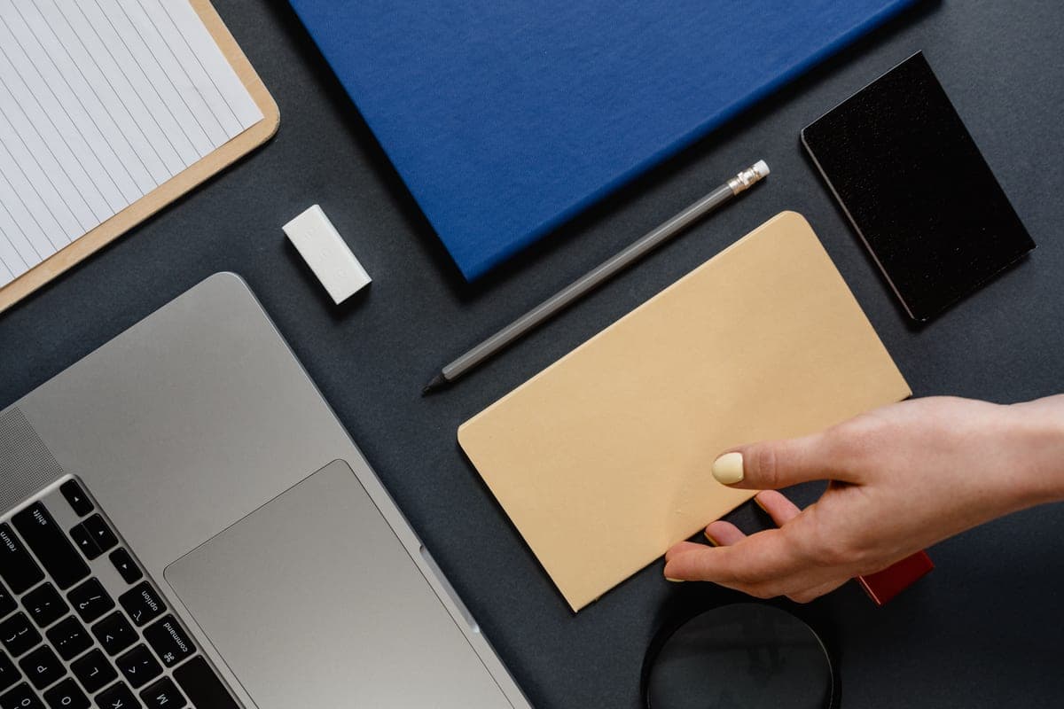 Person closing a laptop on a tidy desk in a small business office