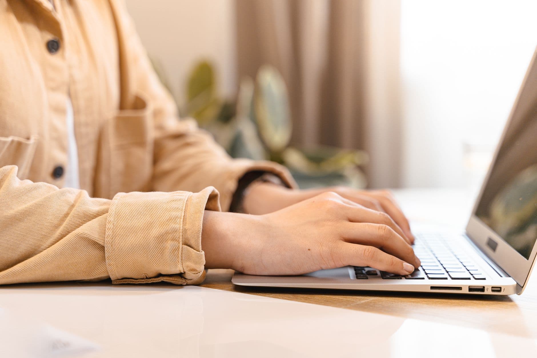 Close-up of hands typing on a laptop keyboard