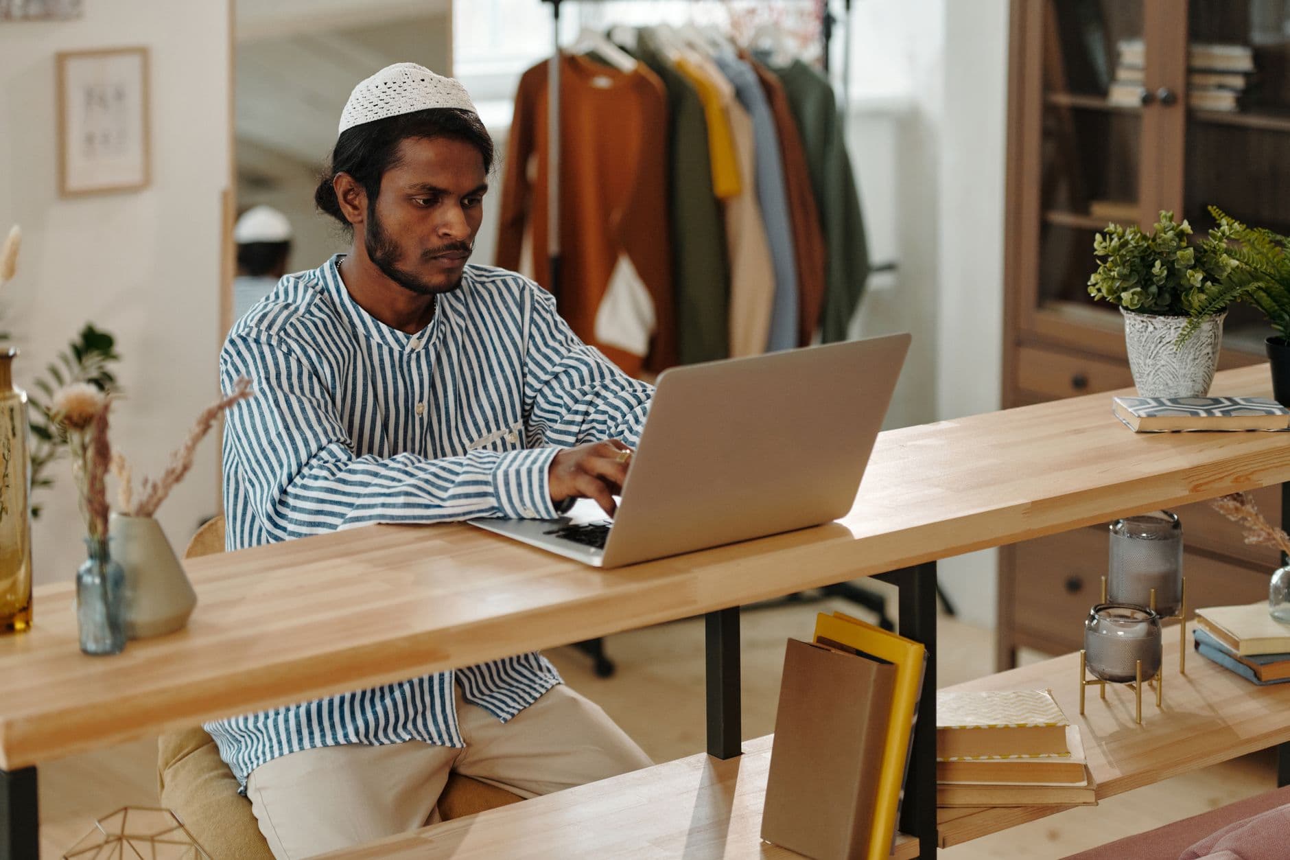 Person working on a laptop at a desk in a home office