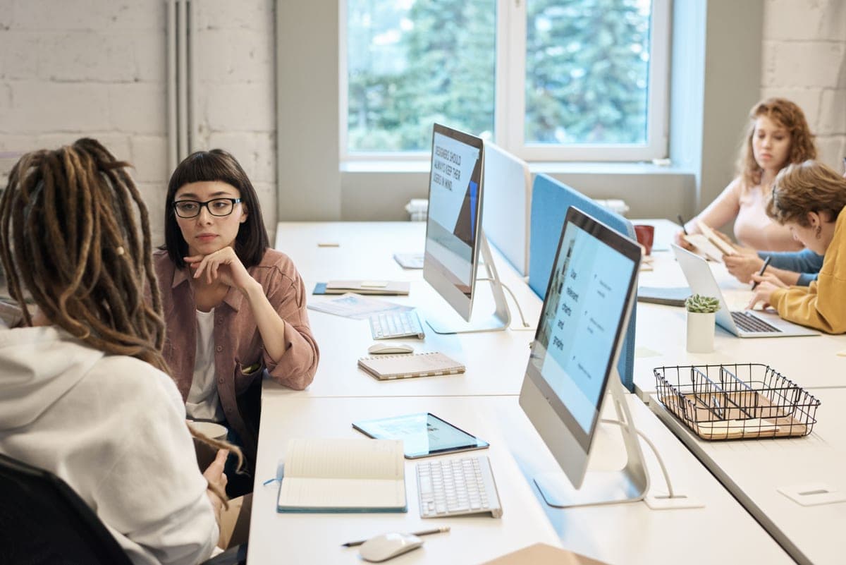 Colleagues working together at desks in an open-plan small office