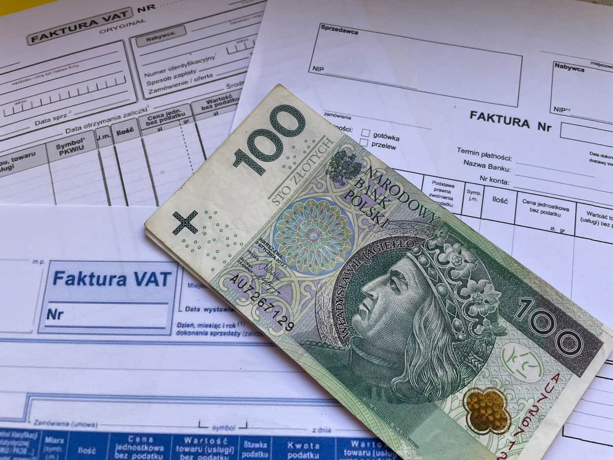 Invoices and a laptop on a desk in a business accounts department