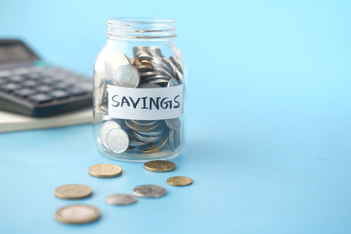 Coins and a notebook on a desk representing business savings