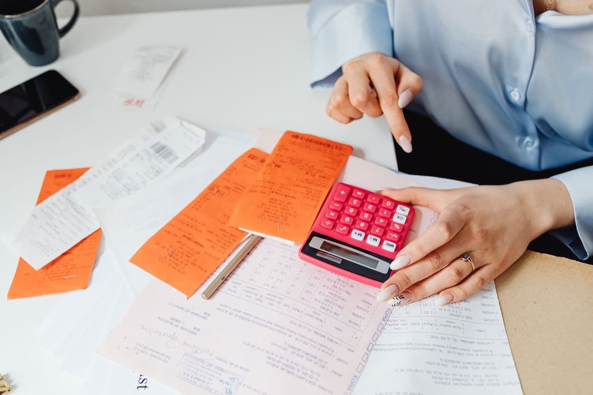 Bookkeeping with receipts and a spreadsheet on a laptop