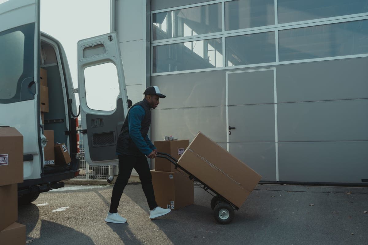 Parcels on a doorstep beside a business delivery crate in a loading area
